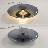 Moderne Tischleuchte PURE Vitrum aus Glas, von oben und seitlich beleuchtet, mit elegantem, flachem Design.