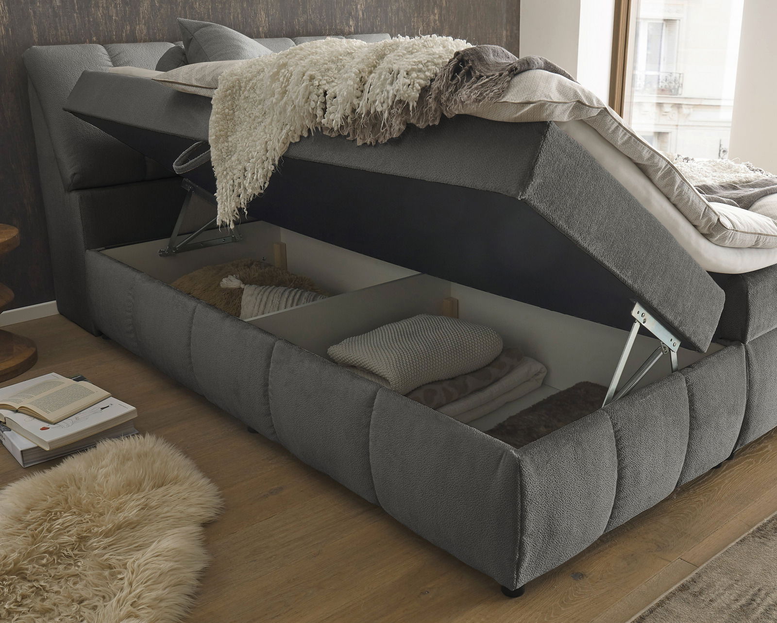 Boxspringbett mit geöffnetem Bettkasten, seitliche Perspektive