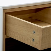 Nahaufnahme einer geöffneten Schublade eines Büroschranks aus Holz mit sichtbaren Schrauben, Perspektive von schräg oben.