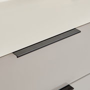 Nahaufnahme in schräger Perspektive von einer Glasplatte mit schwarzer Metallkante/Profil auf hellem Hintergrund