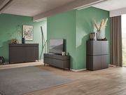 Modernes Wohnzimmer mit einem TV-Lowboard, einem Sideboard und einem Highboard in dunklem Holzdesign, seitliche Perspektive.