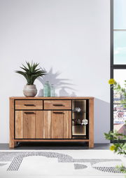 Holz-Sideboard mit zwei Schubladen und offenen Regalfächern, dekoriert mit Pflanzen und Flaschen, aus frontaler Perspektive.