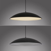 Schwarze, flache Pendelleuchte mit großem, rundem Schirm und weißem Diffusor, warm leuchtend, freigestellt vor grauem Hintergrund, Ansicht leicht von unten/Frontansicht.