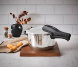 Schnellkochtopf WMF Perfect Neu 4,5L, seitliche Perspektive, auf Holzbrett in moderner Küchenszene mit Kartoffeln und Dekoration.