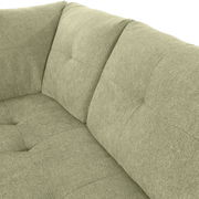 Nahaufnahme einer grünen Sofaecke mit gepolsterten Kissen und texturierter Oberfläche, Perspektive von oben.