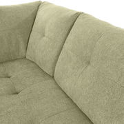 Nahaufnahme einer grünen Sofaecke mit gepolsterten Kissen und texturierter Oberfläche, Perspektive von oben.