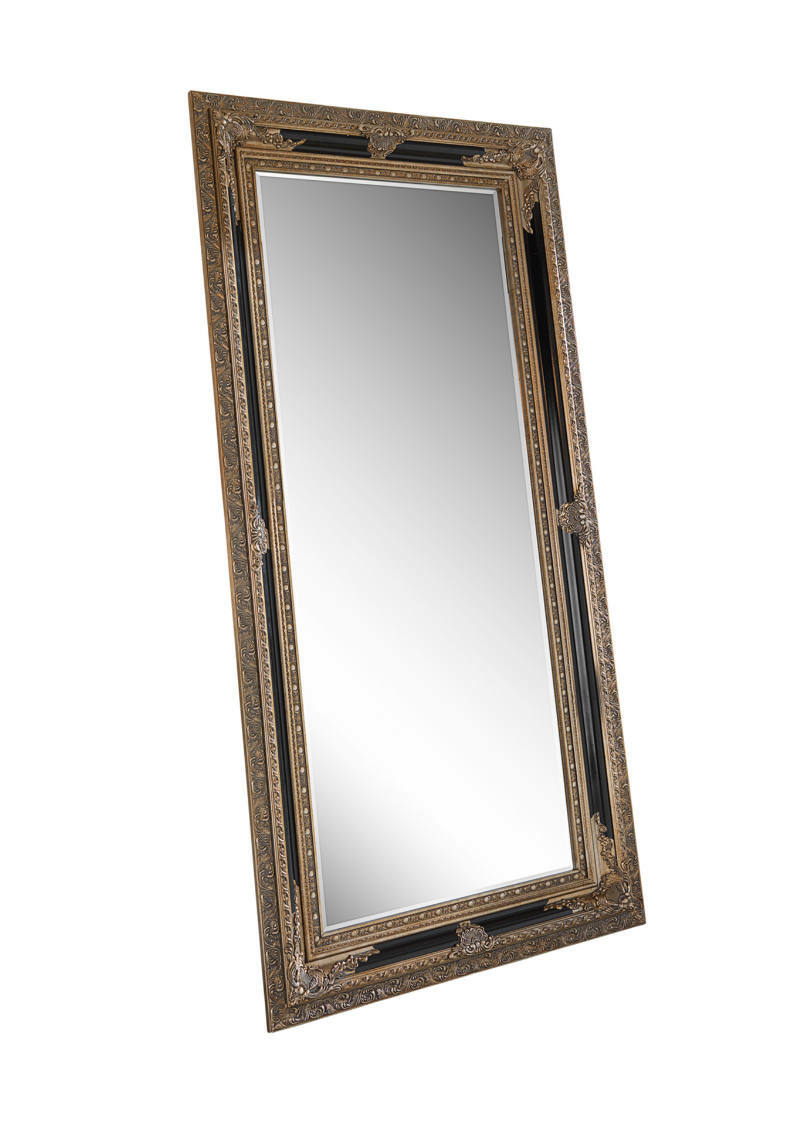 Großer rechteckiger Spiegel mit reich verziertem, goldfarbenem Rahmen, in schräger Perspektive fotografiert.