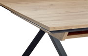 Nahaufnahme eines Vierfußtisches mit Holzoptik und schwarzen Metallbeinen, perspektivisch von der Ecke aufgenommen.