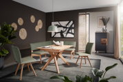 Moderner Essbereich mit einem Holztisch und grünen Stühlen, Eckbank und stilvoller Dekoration, seitliche Perspektive.