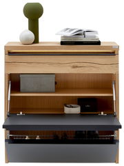 Schuhschrank aus hellem Holz mit geöffneter Klappe in Anthrazit, Innenfächern und Drahtkorb, oben mit Deko und Büchern, Frontansicht.