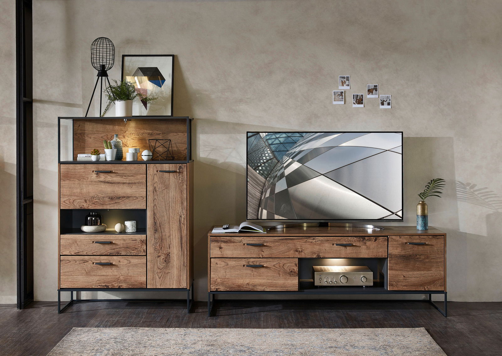 Zurbrüggen Wandkombination MANHATTAN Wohnzimmeransicht mit moderner Wandkombination aus Holz und Metall, bestehend aus einem hohen Schrank mit Dekoration und einem TV-Unterteil mit Flachbildfernseher, von vorne betrachtet.