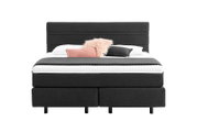 Boxspringbett in dunklem Stoffbezug mit Kopfteil, dekoriert mit Kissen, Frontalansicht