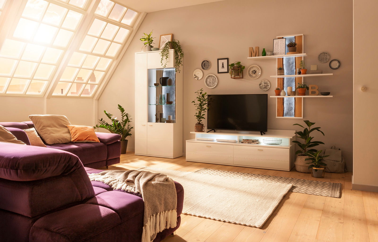 Modernes Wohnzimmer mit einem Hängepaneel in der rechten Wandperspektive, dekoriert mit Pflanzen und Dekorationsgegenständen.