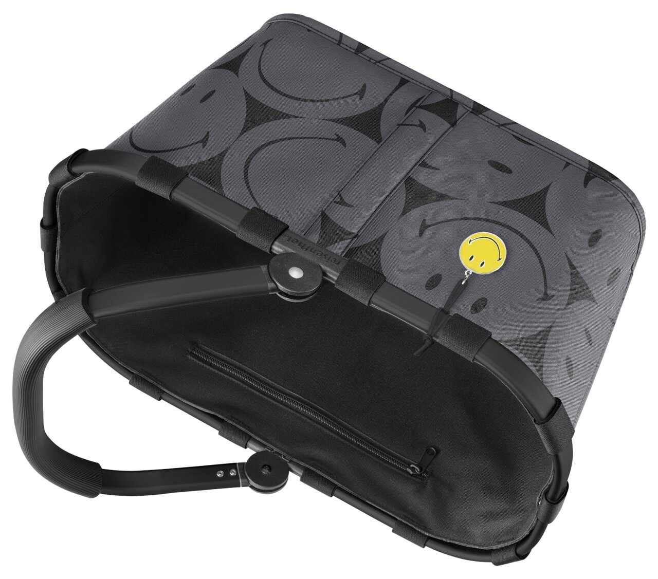 Grauer Einkaufskorb mit schwarzen Smiley-Motiven und gelbem Smiley-Anhänger, von oben betrachtet.