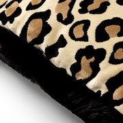 Nahaufnahme eines Dekokissens mit Leopardenmuster und schwarzem Rand.