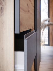 Nahaufnahme eines Schwebetürenschranks mit Holz- und Metallelementen, seitliche Perspektive.