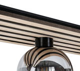 Nahaufnahme einer modernen Deckenleuchte mit gestreiftem Holzdesign und gläsernem Lampenschirm, von unten betrachtet.