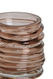 Nahaufnahme eines gestapelten, spiralförmigen Teelichthalters aus braunem Glas mit glänzender Oberfläche.