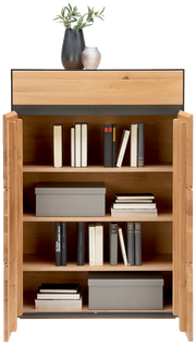 Hochkommode aus Holz mit offenen Türen, gefüllt mit Büchern und Aufbewahrungsboxen, dekoriert mit Vasen auf der Oberseite, Frontalansicht.