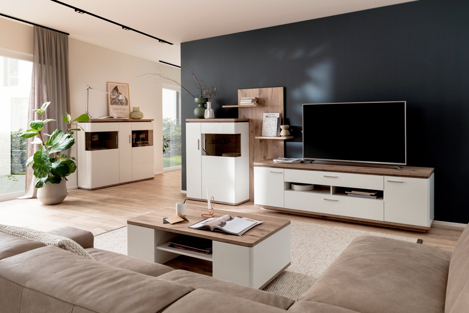 Modernes Wohnzimmer mit weißer Wohnwand und TV-Board mit Holzoptik, Vitrine, Sideboard und Couchtisch, aufgenommen in frontaler Perspektive mit leichter Weitwinkelansicht.