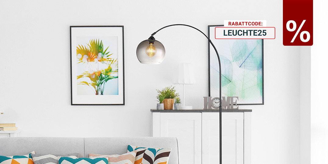 Modernes Wohnzimmer mit grauem Sofa, bunten Kissen, Bogen-Stehlampe und zwei Bildern an weißer Wand