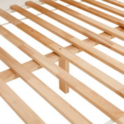 Nahaufnahme eines Holzlattenrosts aus hellem Holz, perspektivisch von oben fotografiert.