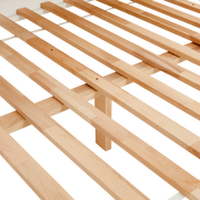 Nahaufnahme eines Holzlattenrosts aus hellem Holz, perspektivisch von oben fotografiert.