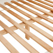 Nahaufnahme eines Holzlattenrosts aus hellem Holz, perspektivisch von oben fotografiert.