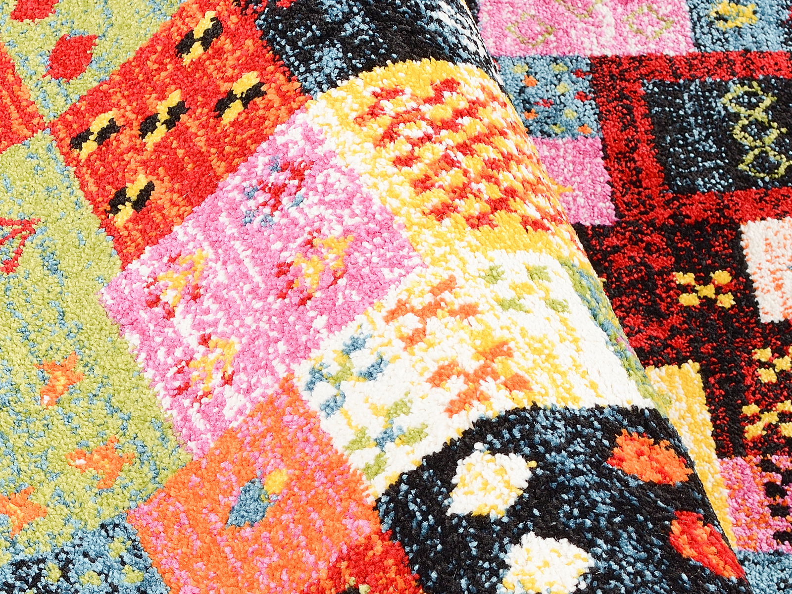 Bunter Designer Teppich mit geometrischen Mustern in leuchtenden Farben, aus der Nahaufnahme Perspektive.