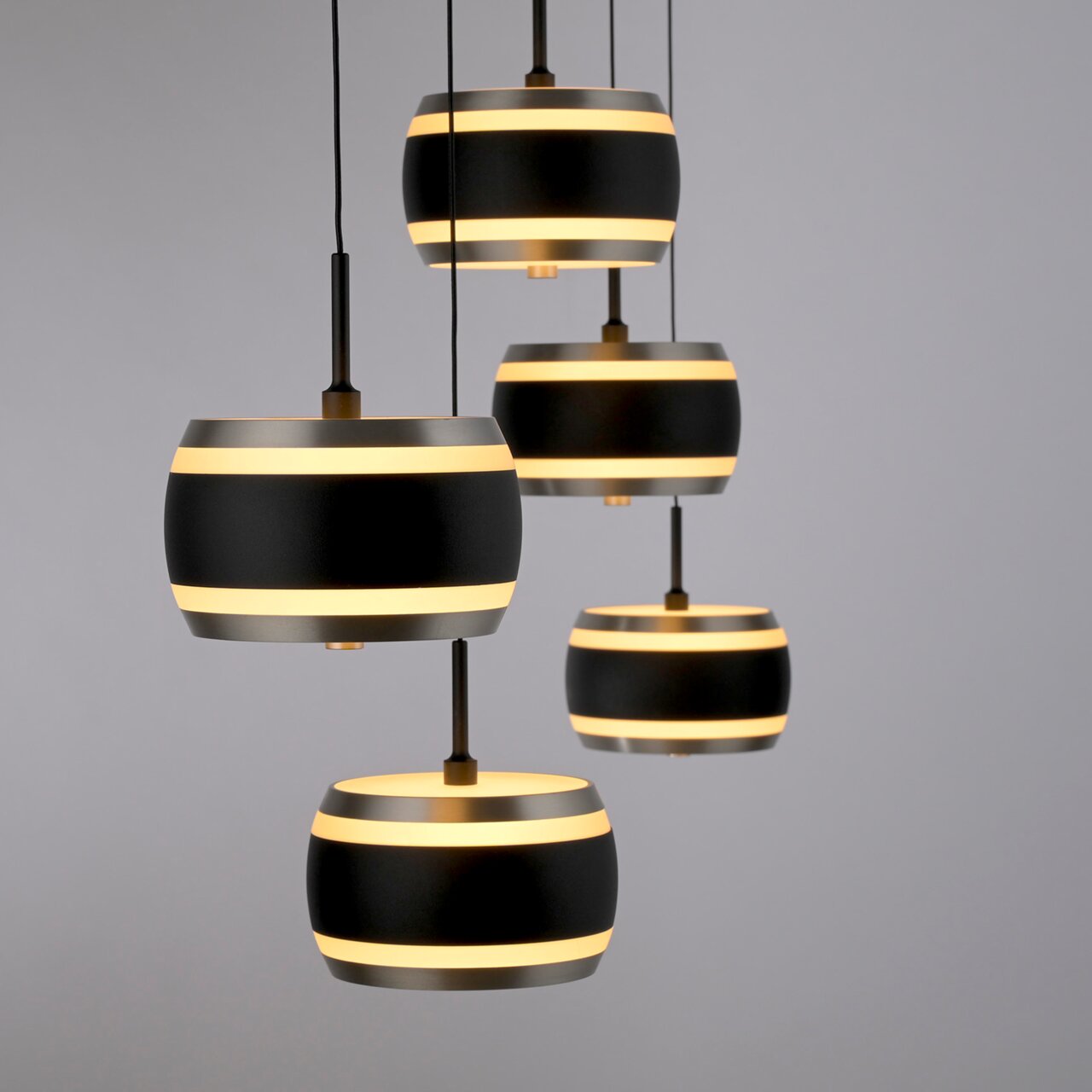 Moderne LED-Pendelleuchte mit mehreren schwarzen und goldenen Schirmen, seitliche Perspektive