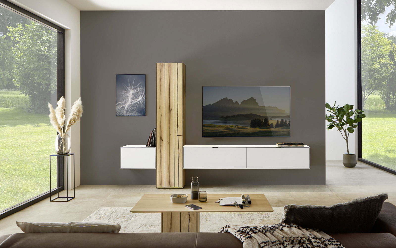 Moderne Wohnzimmerwandkombination mit hölzernem Schrank, weißen Schubladen und einem großen Fernseher, frontal betrachtet.