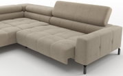 Beiges L-förmiges Ecksofa mit Cordbezug, gesteppten Sitzflächen, hoher Rückenlehne und schwarzen Metallfüßen, in schräger Frontansicht von rechts