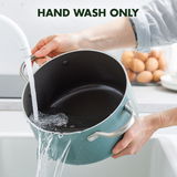 Eine Person spült einen großen, grünen Kochtopf von Hand unter fließendem Wasser. Der Topf hat zwei Griffe und wird über einem Waschbecken gehalten. Im Hintergrund sind Eier zu sehen. Perspektive: seitlich von oben.