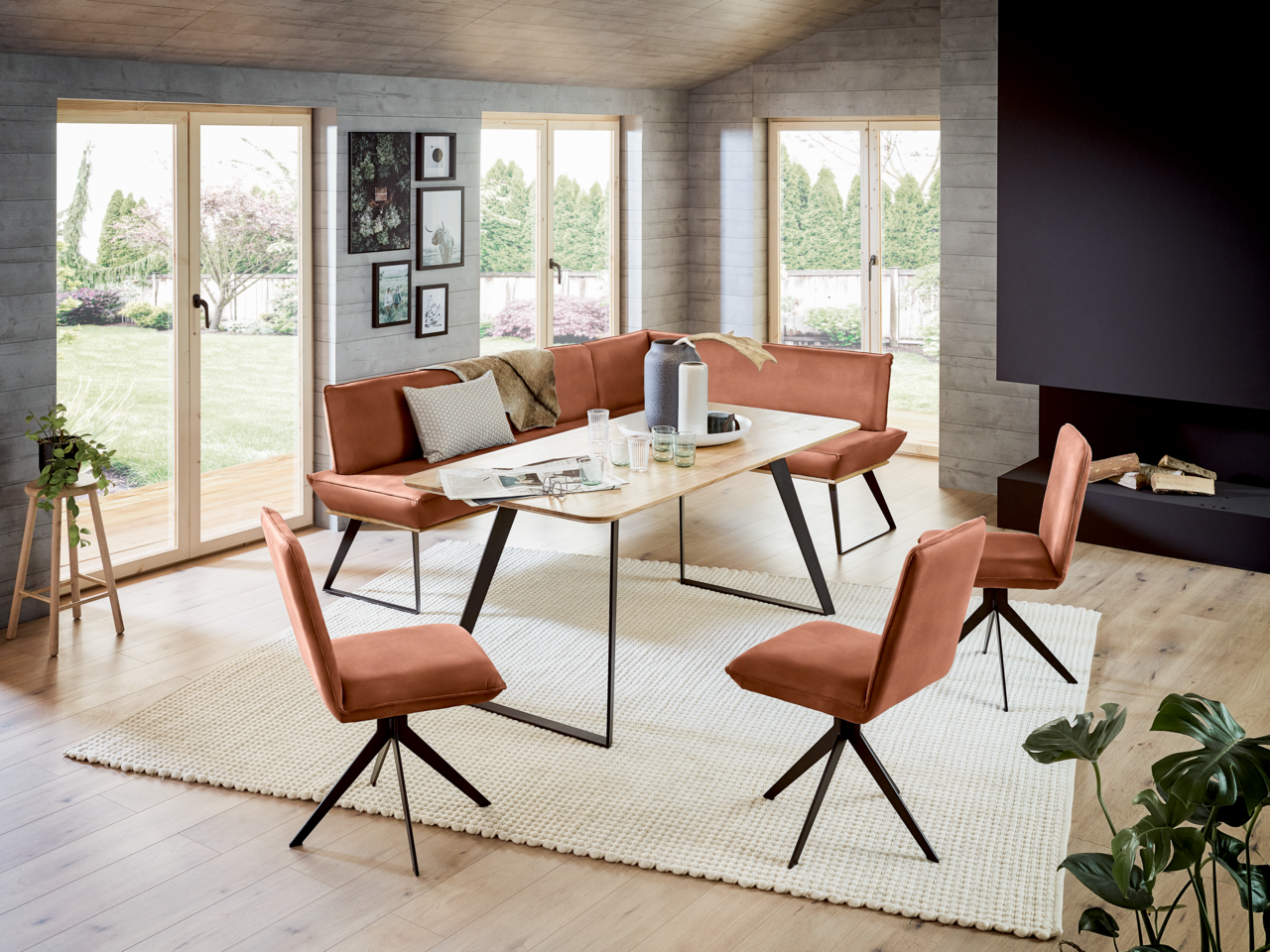 Voleo Eckbank 243x163 cm MALIBU Moderne Eckbank 243x163 cm in einem hellen Wohnzimmer mit großen Fenstern, umgeben von passenden Stühlen und einem Holztisch, aus der Perspektive des Raumes fotografiert.