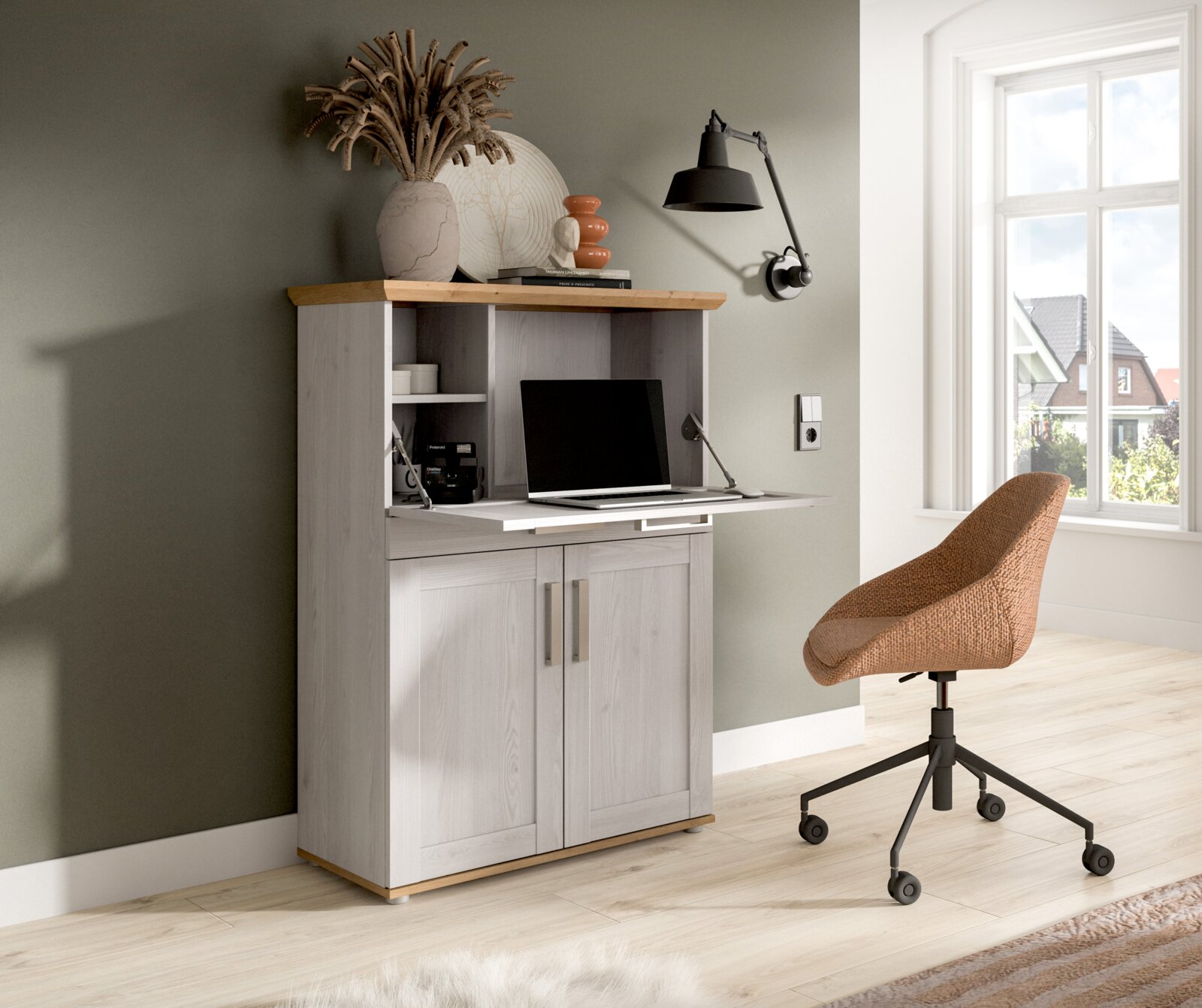 Sekretär-Schrank in hellgrauer Holzoptik mit ausklappbarer Schreibtischplatte und offenen Fächern, im Wohnzimmer-Homeoffice eingerichtet; Ansicht leicht schräg von vorn links.
