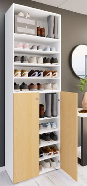 Hoher weißer Schuhschrank mit mehreren offenen Regalböden und zwei hellen Holztüren unten, gefüllt mit Sneakers und Stiefeln; Perspektive: frontale Ansicht leicht von links