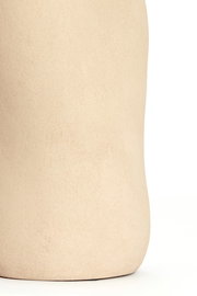 Nahaufnahme einer sandfarbenen Vase mit glatter Oberfläche, seitliche Perspektive