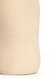 Nahaufnahme einer sandfarbenen Vase mit glatter Oberfläche, seitliche Perspektive