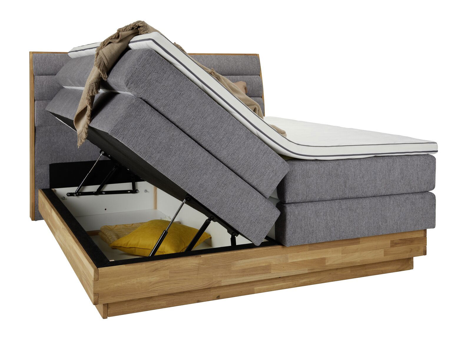 Boxspringbett mit hochgeklappter Matratze und sichtbarem Stauraum, seitliche Perspektive