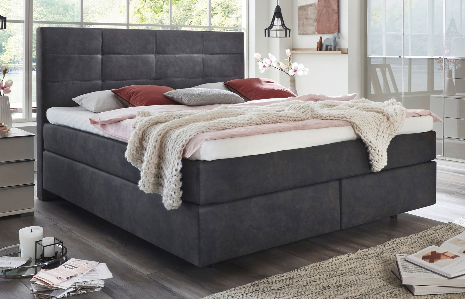 Gemütliches Boxspringbett in modernem Schlafzimmer, seitliche Perspektive