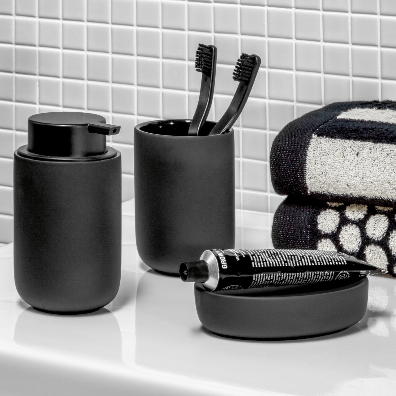 Schwarzes Badezimmer-Set bestehend aus Seifenspender, Zahnputzbecher und Seifenschale, seitliche Perspektive