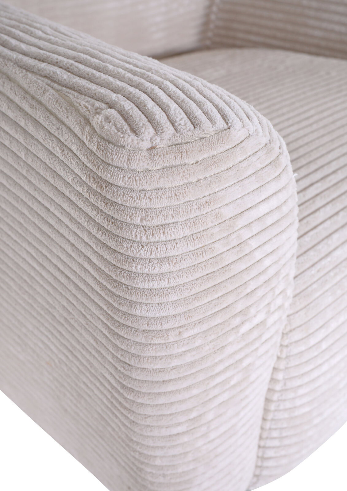 Detailaufnahme der Armlehne eines hellbeigen Cord-Sofas mit weicher, gerippter Struktur, schräg von vorne oben fotografiert