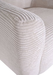 Detailaufnahme der Armlehne eines hellbeigen Cord-Sofas mit weicher, gerippter Struktur, schräg von vorne oben fotografiert