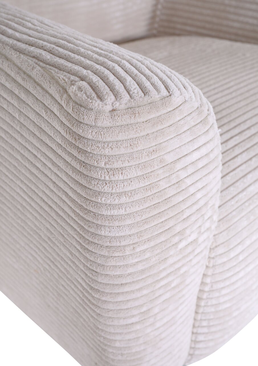 Detailfoto van de armleuning van een lichtbeige corduroybank met een zachte, geribbelde structuur, schuin van voren bovenaf gefotografeerd