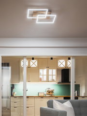 Moderne LED-Deckenleuchte mit zwei überlappenden rechteckigen Rahmen, von unten in einer stilvollen Küche betrachtet.