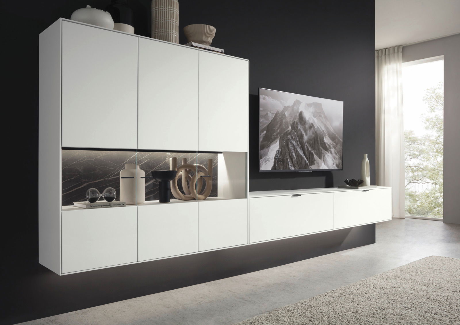 Moderne weiße Wandkombination mit dekorativen Elementen und einem Fernseher, seitliche Perspektive