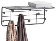 Schwarze Wandgarderobe aus Metall mit mehreren Haken, zwei aufgehängten Tüchern und einer Ablagefläche, seitliche Perspektive
