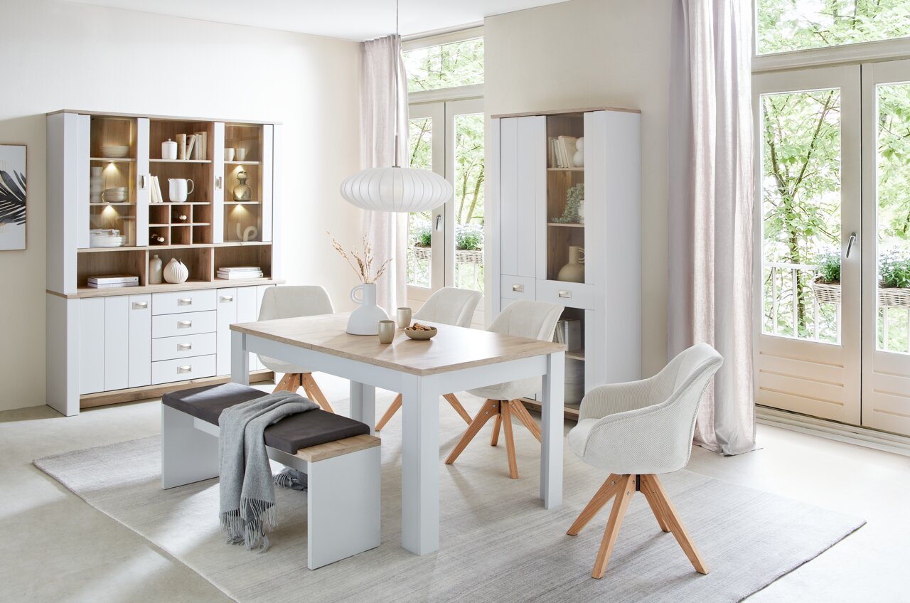 Hom´in Sideboard ETIENNE Esszimmer mit modernem Esstisch, Stühlen und Bank in heller, freundlicher Atmosphäre. Perspektive von vorne auf den Tisch und die umgebenden Möbel.