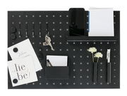 Schwarzes Memoboard mit Utensilien aus der Vogelperspektive, inklusive Haken, Notizblock, Smartphone-Halter, Stifthalter und dekorativen Elementen.