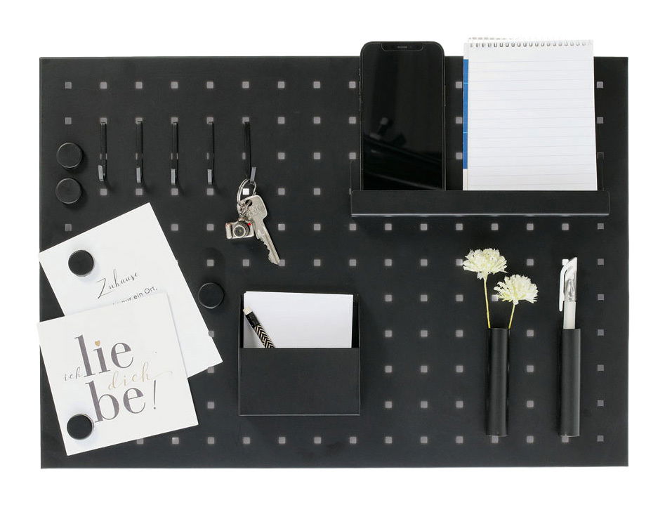 Schwarzes Memoboard mit Utensilien aus der Vogelperspektive, inklusive Haken, Notizblock, Smartphone-Halter, Stifthalter und dekorativen Elementen.